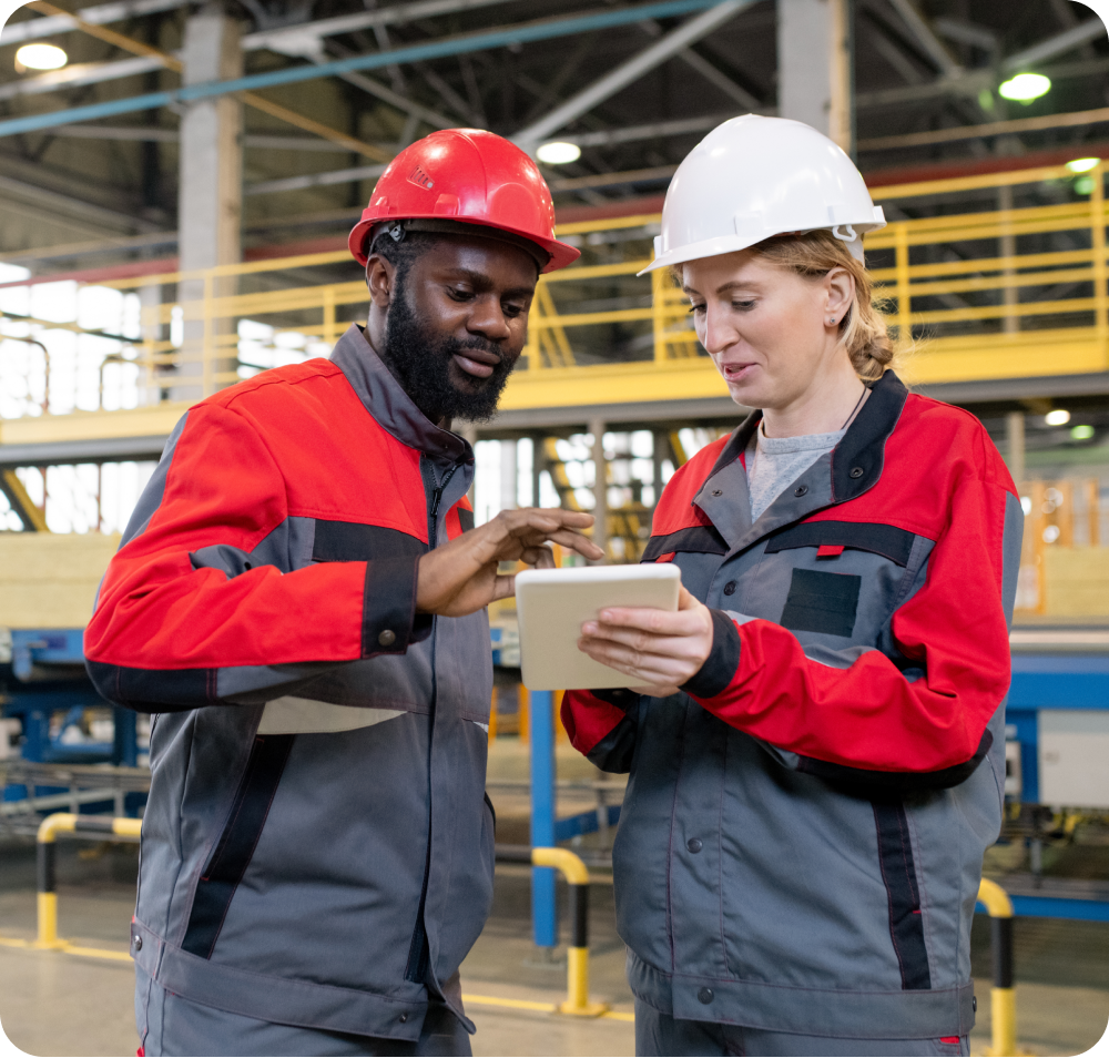 Male and female factory worker collaborating on tablet