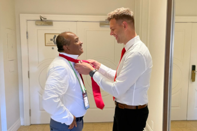 Male colleague helping ty another colleague's red tie