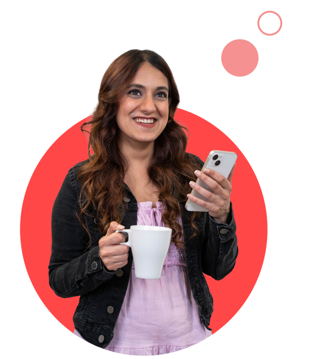 Colleague smiling while holding a phone and a cup