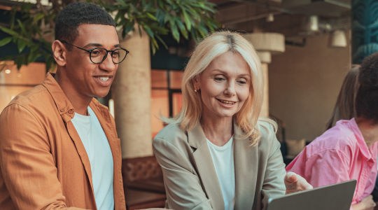 image of man and woman looking happily at a laptop screen