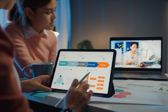 image of people looking at a screen with a workflow/dashboard. image used as feature image for servicenow flow designer and servicenow workflows blog