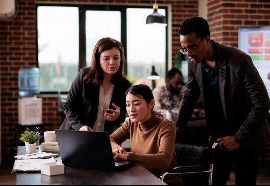 feature image for Genai adoption blog. image of 3 people looking at a computer screen.