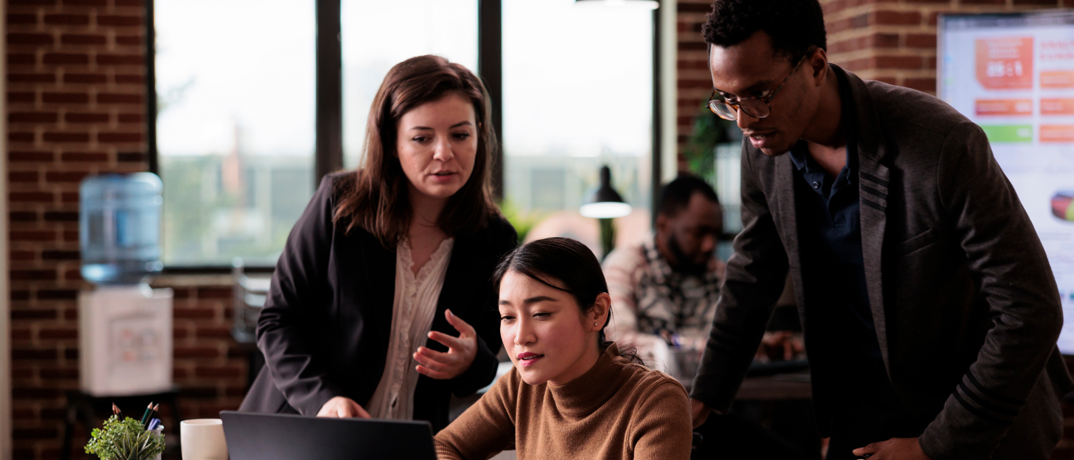 feature image for Genai adoption blog. image of 3 people looking at a computer screen.