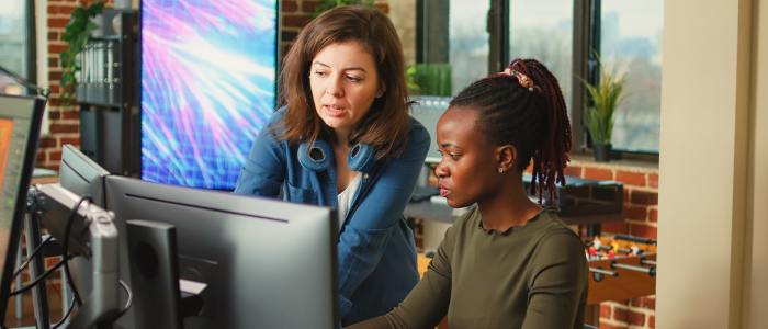 Visual of two women looking at a monitor screen. Used as a visual for ServiceNow quality blog