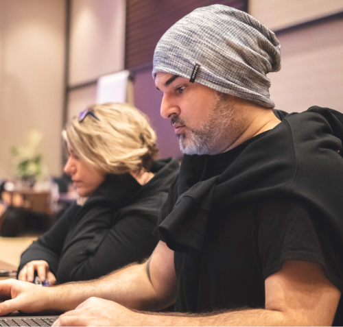 Person with a gray hat working on a laptop