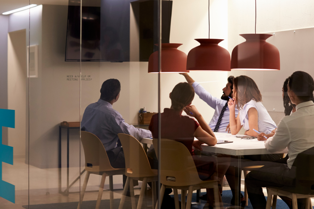 group of people sitting at a table in a meeting room at the office. Image used as a visual for WSD use cases blog